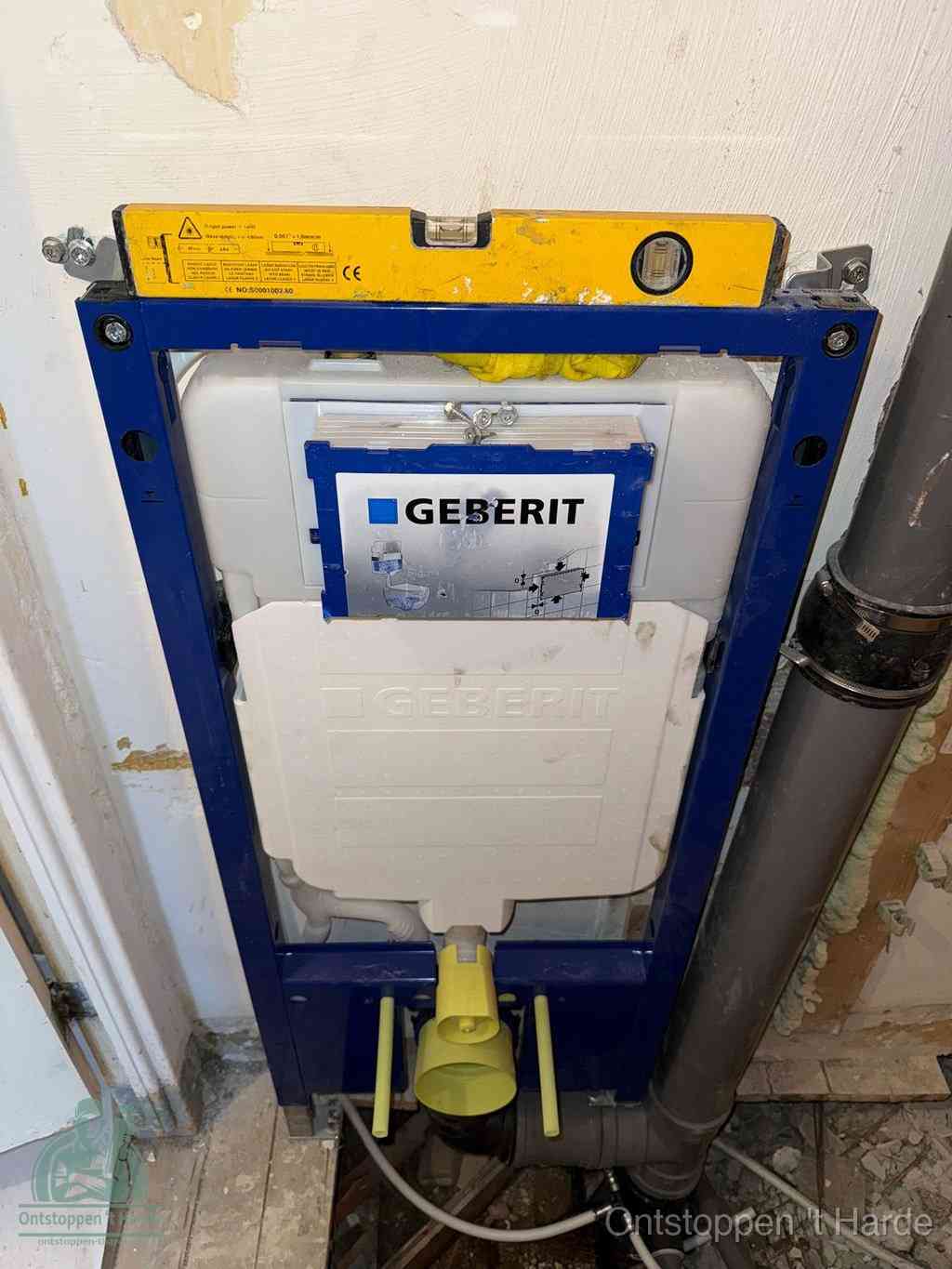 Een Geberit inbouwreservoir met frame voor een hangtoilet tegen de wand, met de afvoerbocht naar de vloer, kenmerkend voor een verstopt hangtoilet in t Harde