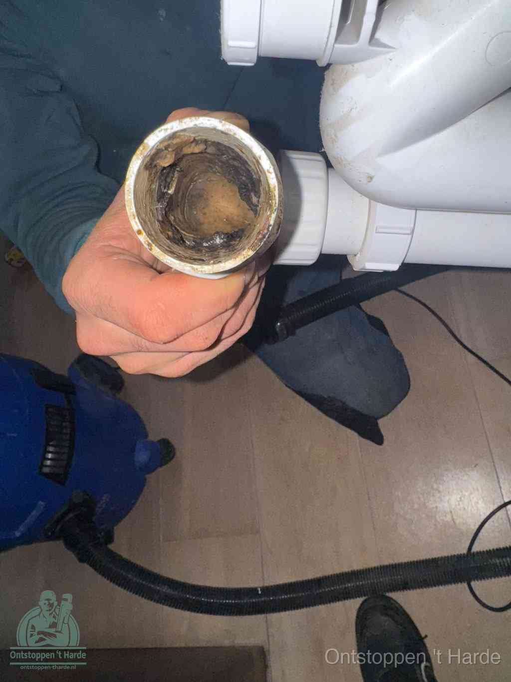 Een losgekoppelde afvoerbuis die van binnen volledig is dichtgeslibd met vet en aanslag, de meest voorkomende oorzaak van een verstopte gootsteen in t Harde