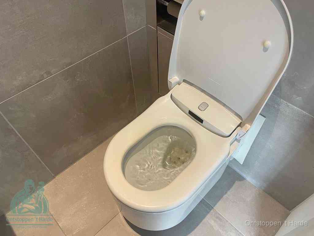 Een toiletpot vol troebel water met drijvend papier en restanten, de meest voorkomende oorzaak van een verstopte wc in t Harde
