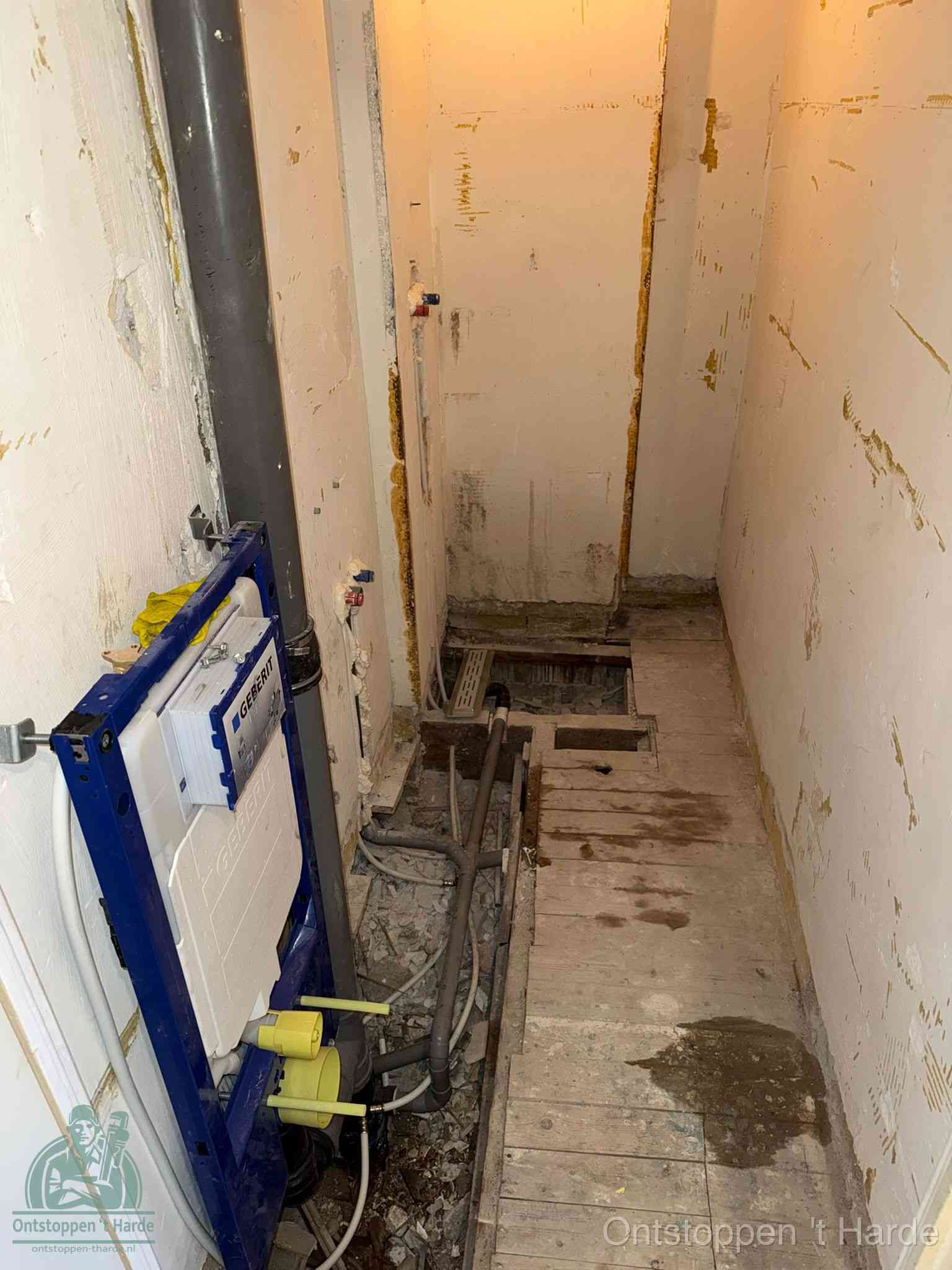 Een opgebroken toiletruimte tijdens renovatie met een Geberit inbouwreservoir en blootliggende oude afvoerleidingen, typisch voor oudere woningen in t Harde
